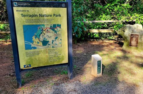 Sign welcoming visitors to Terrapin Nature Park, with a "START" marker and lush greenery in the background.