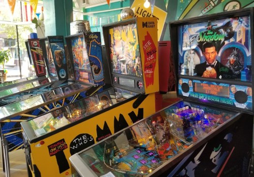 A colorful arcade featuring vintage pinball machines with various themes and designs.
