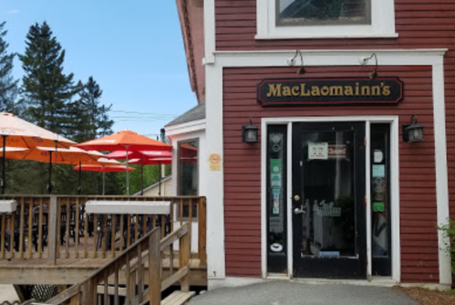 Exterior of MacLaomainn's restaurant with a wooden deck and orange umbrellas on a sunny day.