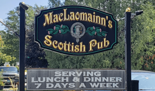 Sign for MacLaomainn's Scottish Pub, featuring decorative text and announcing lunch and dinner served daily.