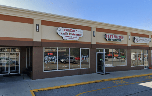 Exterior view of a strip mall featuring Concord Family Restaurant and P & P's Pizzeria, with "Open" signs visible.