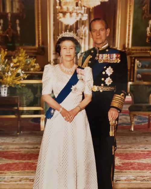 A formal portrait of a woman in a white gown and tiara, standing beside a man in military uniform, in an ornate room.