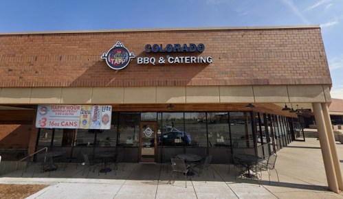 Exterior of Colorado BBQ & Catering restaurant with a sign and outdoor seating area.