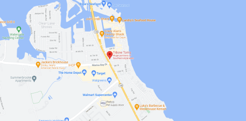 Map showing a coastal area with restaurants, shops, and a marina near the water.