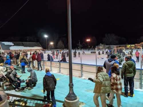 A bustling outdoor ice skating rink at night, with people skating and enjoying the winter atmosphere.