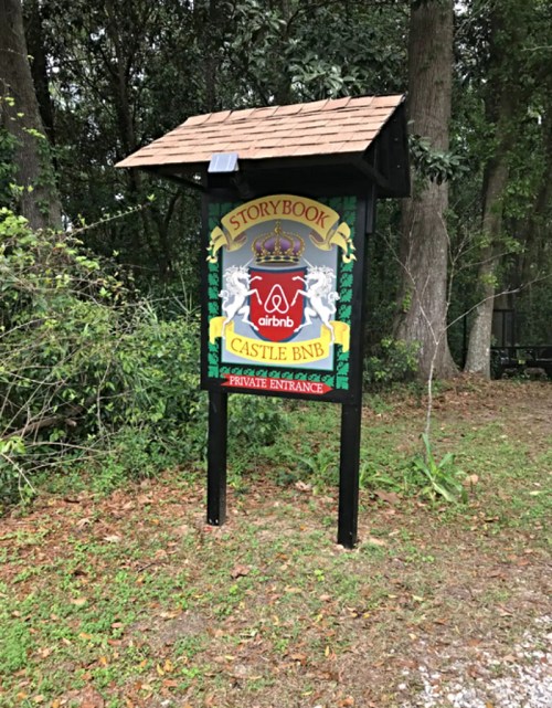 Sign for "Storybook Castle BnB" with Airbnb logo, featuring decorative elements and a private entrance indication.