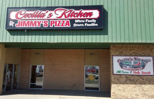 Sign for "Cecilia's Kitchen & Jimmy's Pizza" with "Open" and daily specials displayed on the storefront.