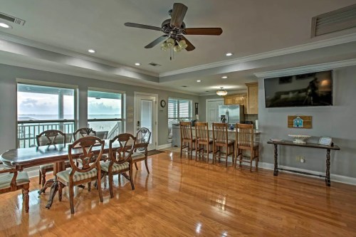 Bright, spacious living area with dining table, bar seating, and large windows overlooking a scenic view.