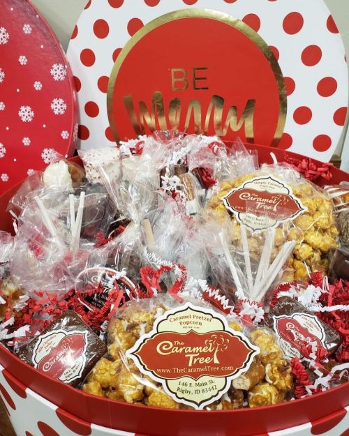 A festive red and white gift box filled with assorted popcorn, pretzels, and treats, labeled "The Caramel Tree."