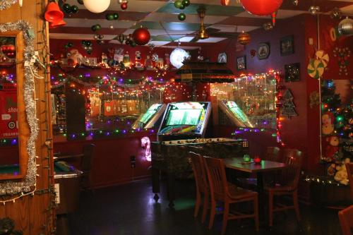 A cozy game room decorated with colorful lights, featuring arcade machines and festive holiday decor.