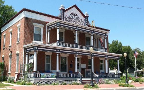 Historic brick building with a decorative facade, labeled "Hotel Kilroy," featuring a porch and American flag.