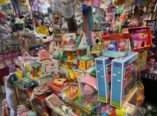 A colorful display of various toys and stuffed animals stacked in a shop, creating a vibrant and playful atmosphere.
