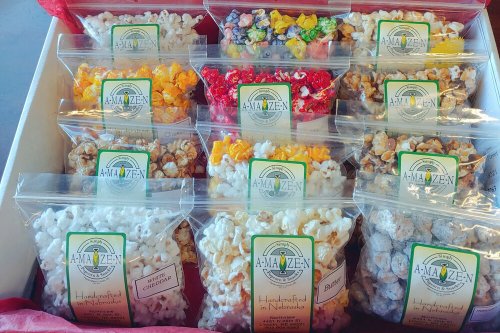 A colorful assortment of popcorn bags in a box, featuring various flavors and vibrant colors.