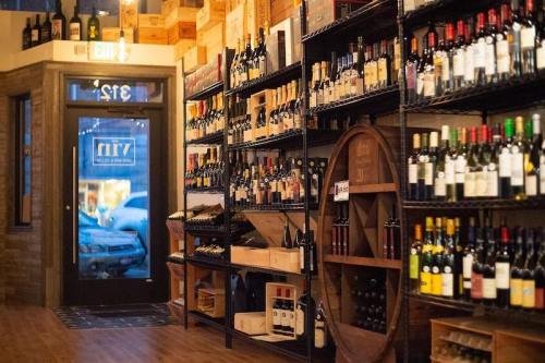 A wine shop interior featuring shelves of various wine bottles and a door leading outside.