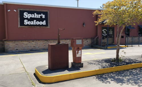 Exterior of Spahr's Seafood with a vintage gas pump and a mailbox in the foreground, surrounded by a parking area.