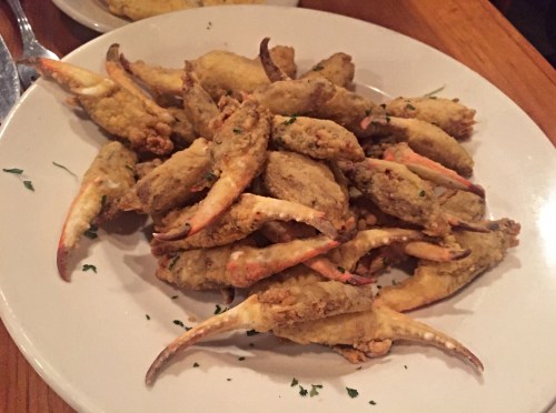 A plate of crispy fried crab claws garnished with parsley.