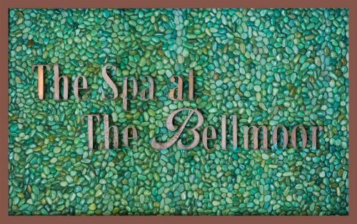Sign reading "The Spa at The Bellmoor" on a textured background of green pebbles.