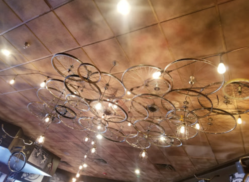 A ceiling decorated with bicycle wheels and hanging light bulbs, creating a unique and artistic ambiance.