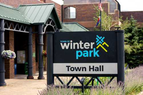 Sign for the Town Hall of Winter Park, featuring the town's logo and a welcoming entrance with greenery.