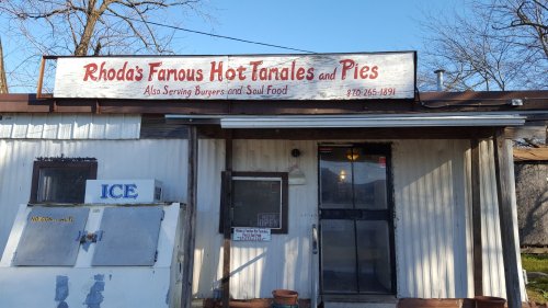 Sign for Rhoda's Famous Hot Tamales and Pies, featuring a menu of tamales, pies, burgers, and soul food.