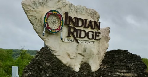Sign for Indian Ridge Resort Community, featuring a stone design and colorful dreamcatcher motif.