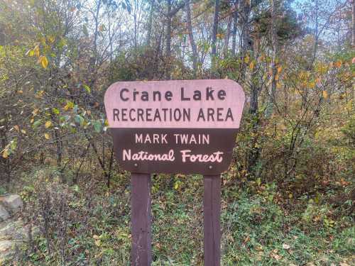 Sign for Crane Lake Recreation Area in Mark Twain National Forest, surrounded by trees and autumn foliage.