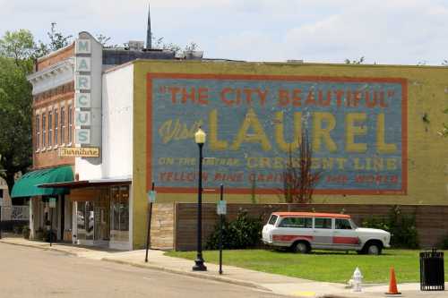 A vintage building with a mural reading "The City Beautiful" and a classic van parked nearby.