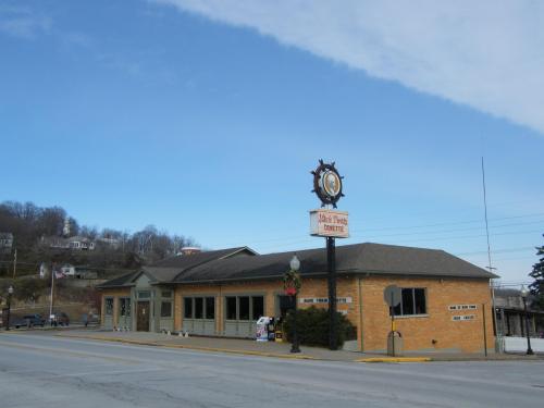 A brick building with a sign reading "Deli & Treats" under a clear blue sky, located on a street.