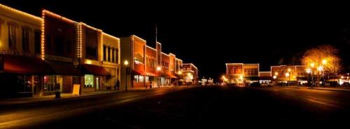 A charming street at night, lined with buildings adorned with warm lights, creating a festive atmosphere.