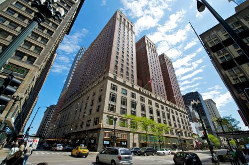 A tall building with a mix of modern and classic architecture, set against a blue sky with scattered clouds.