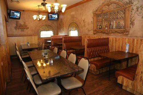 Cozy restaurant interior with wooden accents, booths, and tables, featuring decorative wall art and soft lighting.