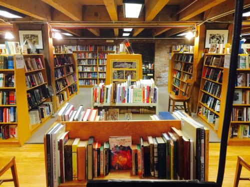 A cozy bookstore interior with wooden shelves filled with books and warm lighting, creating an inviting atmosphere.