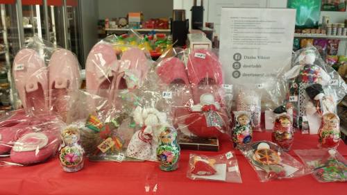 A display of various pink items, including slippers, dolls, and decorative matryoshka nesting dolls, all wrapped in plastic.