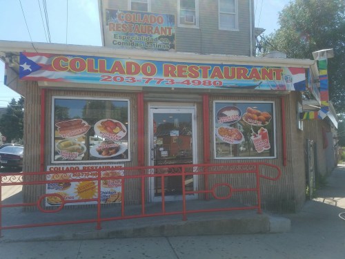 A colorful restaurant exterior with signs advertising Latin cuisine, featuring a menu and contact information.