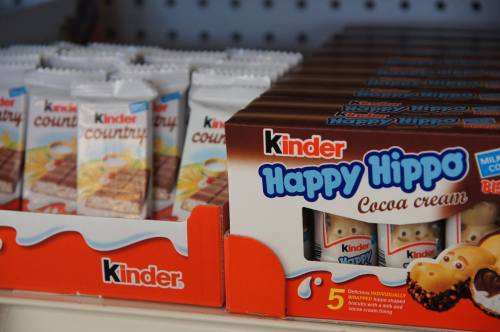 A display of Kinder snacks, featuring Happy Hippo cocoa cream and Kinder Country bars in a store setting.