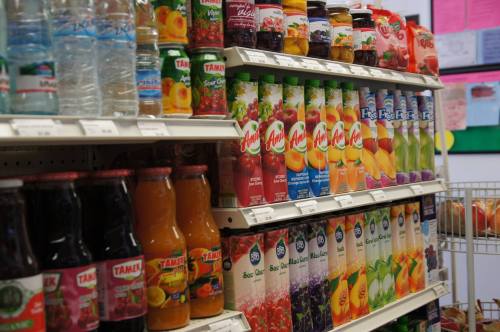A colorful display of various fruit juices and beverages on shelves in a store.