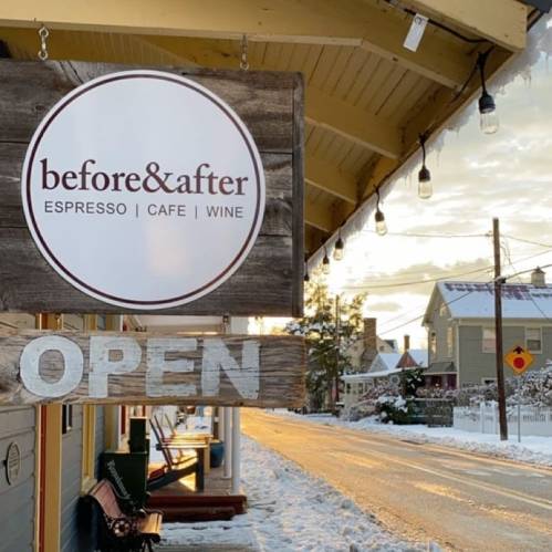 Sign for "before&after" café and wine bar, with an "OPEN" notice, set against a snowy street scene.