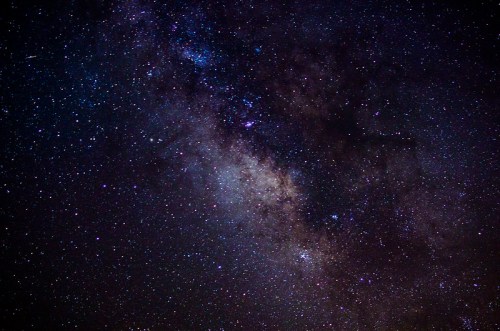 A stunning view of the night sky filled with stars and the Milky Way galaxy, showcasing vibrant colors and cosmic beauty.