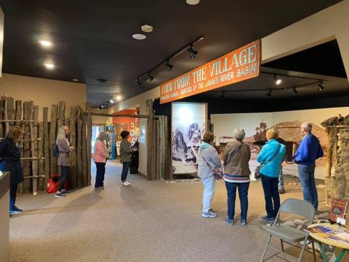 Visitors stand in a museum exhibit titled "A View from the Village," exploring displays about the James River Basin.