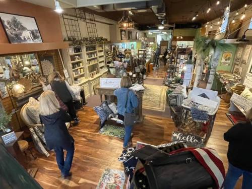A cozy shop filled with home decor items, featuring customers browsing among shelves and displays.