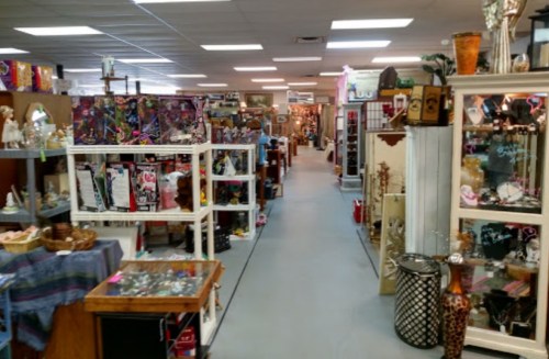 A wide aisle in a vintage shop filled with various antiques and collectibles on display.