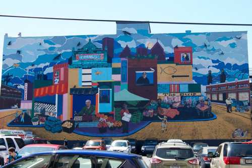 Colorful mural depicting a vibrant market scene with people, buildings, and various produce against a blue sky.