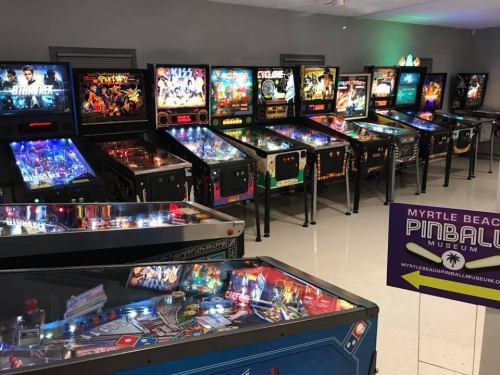 A vibrant display of pinball machines in a museum, showcasing various themes and colorful designs.