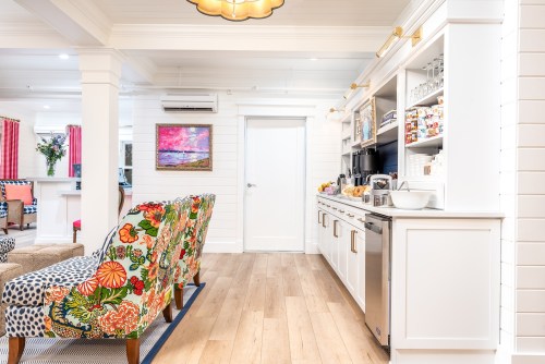 Bright, modern kitchen with colorful patterned chairs, white cabinetry, and a cozy, inviting atmosphere.