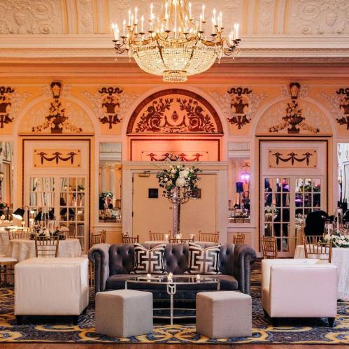 Elegant event space featuring a chandelier, plush seating, and decorative walls, set for a celebration.