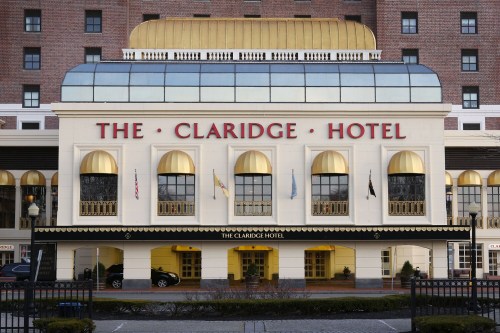 The Claridge Hotel, featuring a grand entrance with arched windows and a gold-accented roof.