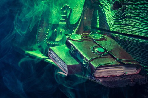 A mystical scene featuring two books, one with glasses on top, surrounded by green smoke and rustic wooden textures.