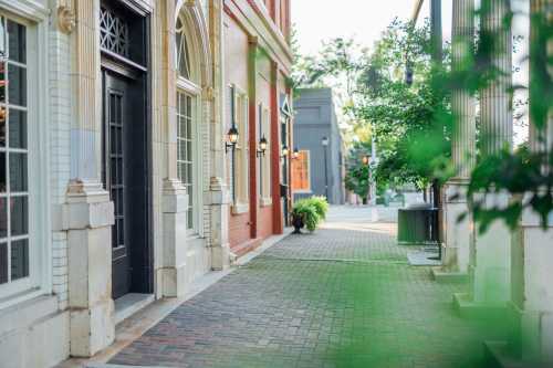 A charming street view featuring brick buildings, decorative lamps, and greenery along the sidewalk.