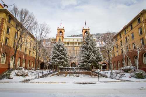 Historic building with towers, surrounded by snow-covered trees and a winter landscape.