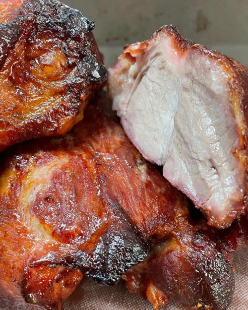 Close-up of succulent, roasted meat with a crispy exterior and tender, juicy interior.